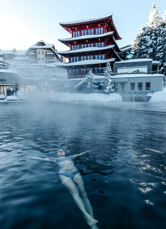 Eine Schwimmerin treibt im beheizten See-Bad vor dem Hotel Hochschober im verschneiten Turracher See.