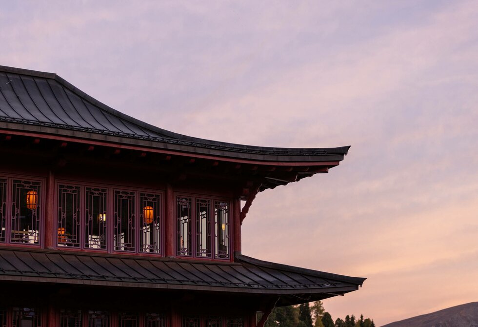 The Chinese tower of Hotel Hochschober stands against a pastel evening sky.