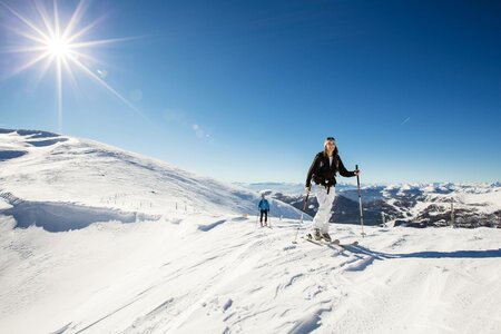 Zwei Personen gehen mit Schneeschuhen durch die verschneite Landschaft auf der Turracher Höhe.