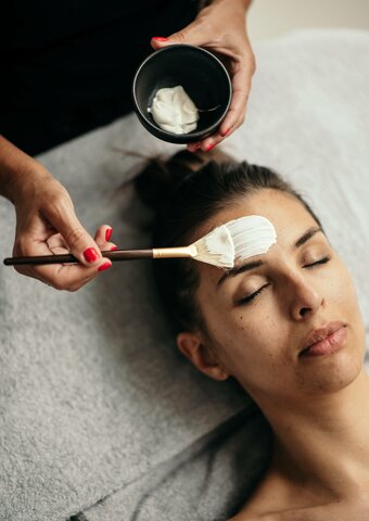 Eine Kosmetikerin trägt eine Creme auf die Stirn einer Frau im Kristall Spa auf.