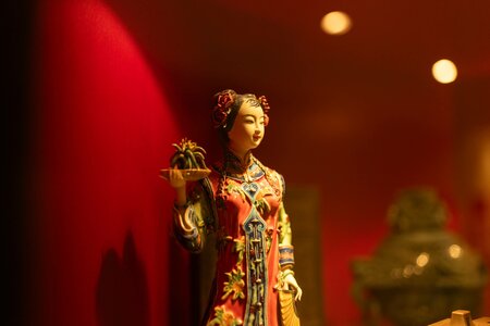 Eine kunstvolle Figur steht vor roter Wandbeleuchtung im Chinaturm des Hotel Hochschober.