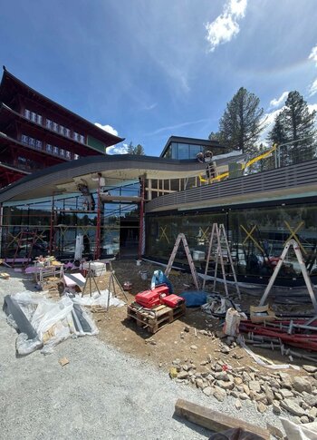 Umbau der Hotelterrasse im Hotel Hochschober Vor dem Hotel Hochschober wird die Terrasse umgebaut; Gerüste, Baumaterial und ein Kran prägen die Baustelle.