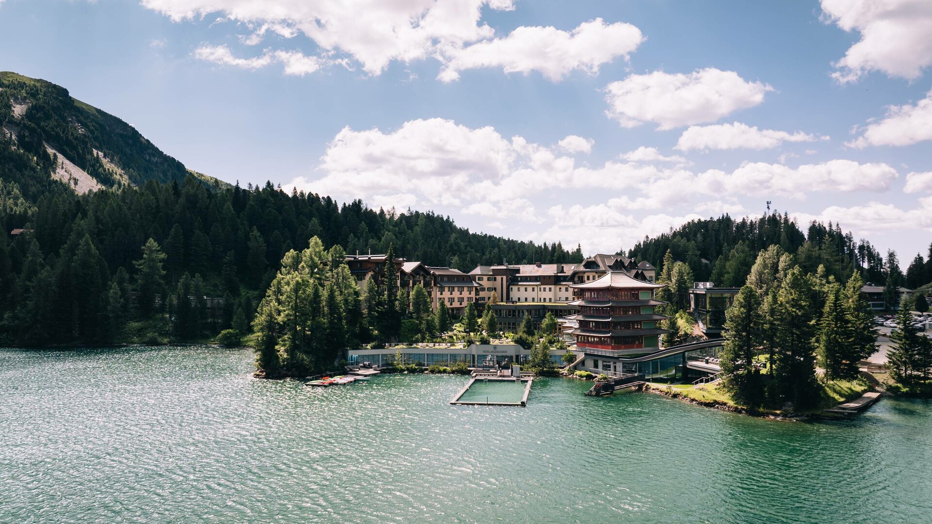 Das Hotel Hochschober liegt direkt am Turracher See, umgeben von Wald und Bergen.