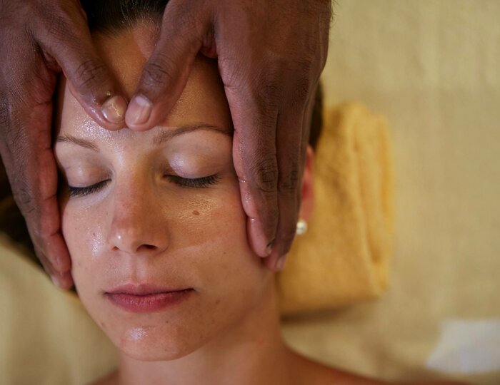 Eine Person erhält eine Shiro-Padabhyanga-Behandlung mit sanfter Kopfmassage im Kristall Spa.