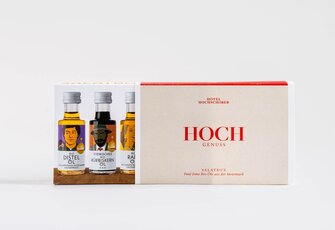 A Hotel Hochschober gourmet box with two small bottles of oil and a salad box stands on a light background.