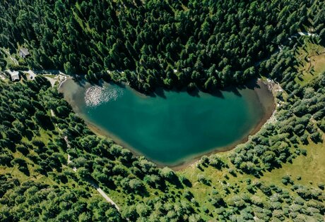 Turracher See lies surrounded by dense forest and alpine meadows in the Nockberge.