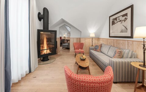 Eine helle Lounge mit Kamin, Sofa, Sesseln und Holzboden im Hotel Hochschober.