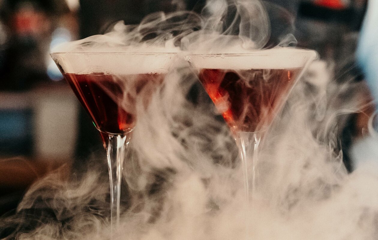 Zwei Cocktails im Martiniglas stehen in dichter Nebelstimmung an der Hotelbar.