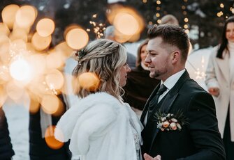 A bride and groom stand facing each other at the hotel wedding reception.