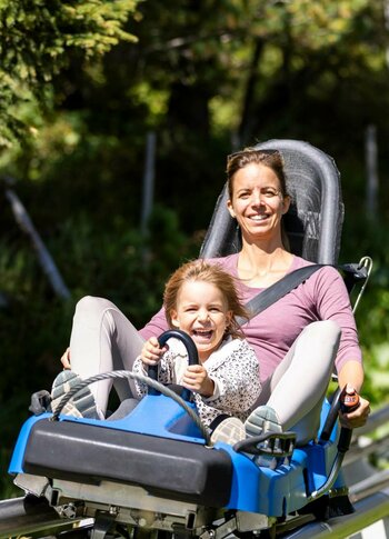 Tochter und Mutter fahren mit dem Nocky Flitzer auf der Turracher Höhe