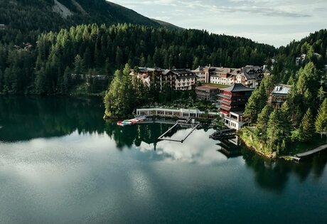Hotel Hochschober stands on the lakeshore with a jetty, boathouse and surrounding forest.