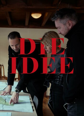 Drei Personen beugen sich über Unterlagen an einem Tisch, darüber steht groß der rote Schriftzug „DIE IDEE“.
