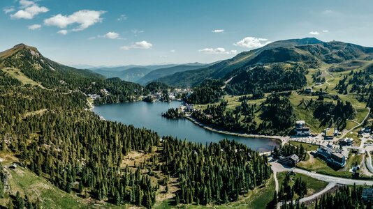 Blick über den Turracher See mit Wäldern, Almen und Bergen in den Nockbergen.