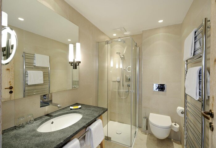 Classic bathroom in the Hotel Hochschober main house A bright bathroom with a vanity, shower, toilet and towel warmer in the classic double room main house.