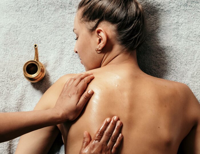 Eine Frau erhält im Kristall Spa eine Abhyanga-Massage auf dem Rücken.