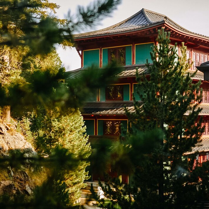 The Chinaturm of Hotel Hochschober is visible between trees, with a green and red facade.