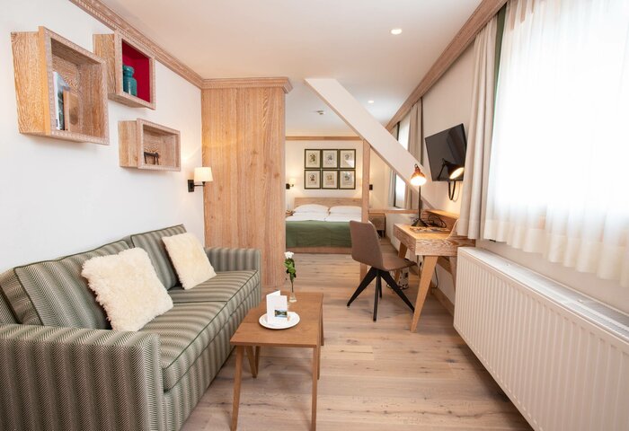Classic double room in the Stammhaus A classic double room in the Stammhaus with sofa, wooden furniture, desk, bed and a large window.
