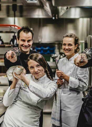 Küchenteam im Hotel Hochschober Vier Mitglieder des Küchenteams stehen in der Hotelküche und blicken in die Kamera.
