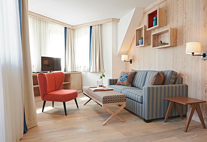 A living area in the Bergkristall apartment with a sofa, armchair, coffee table and bright window section.