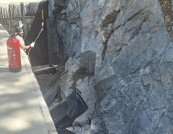 Bauarbeiten am Felsenweg im Hotel Hochschober Ein Arbeiter mit Bohrgerät arbeitet an einer Felswand neben einem Weg auf der Baustelle des Hotel Hochschober.