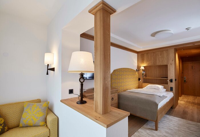 Single room with lounge area at Hotel Hochschober A single room with a bed, wood details and an integrated lounge area at Hotel Hochschober.
