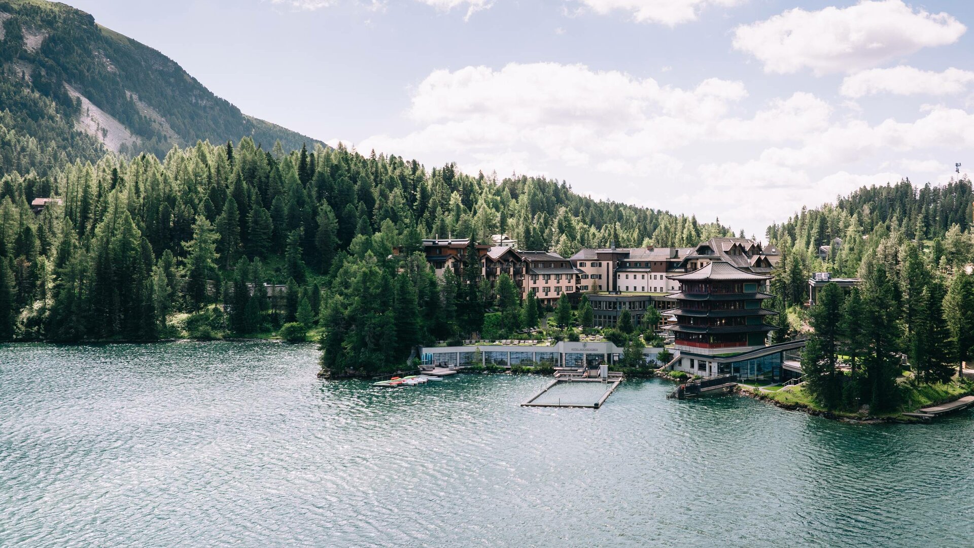 Das Hotel Hochschober liegt am Ufer des Turracher Sees, umgeben von dichtem Wald und Bergen.