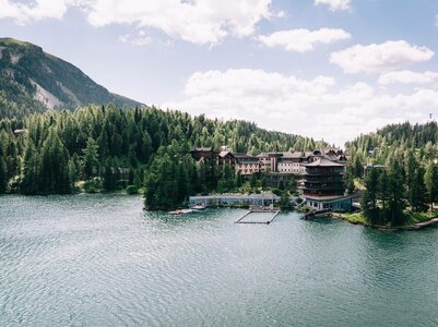 Das Hotel Hochschober liegt am Ufer des Turracher Sees, umgeben von dichtem Wald und Bergen.
