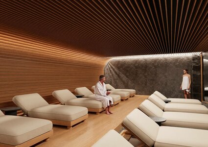 A serene spa room featuring wooden walls and a curved ceiling. Two individuals, one in a robe and the other in a light dress, are present among several comfortable lounge chairs. Soft lighting enhances the tranquil atmosphere.