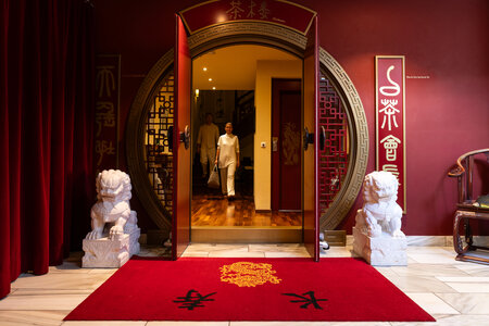 Ein geöffneter Eingang mit roten Wänden, chinesischen Elementen und rotem Teppich im Chinaturm des Hotel Hochschober.