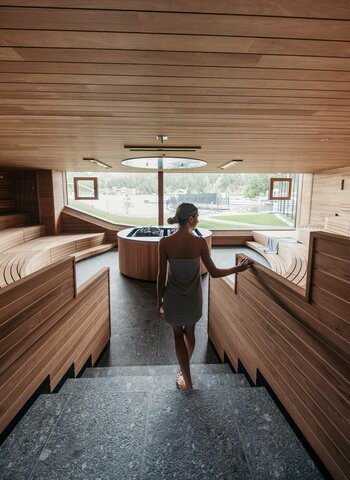 Eine Frau betritt die Arena-Sauna im Hotel Hochschober auf der Turracher Höhe.