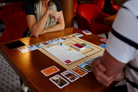 Mehrere Personen spielen ein Brett- oder Kartenspiel an einem Tisch im Hotel Hochschober.