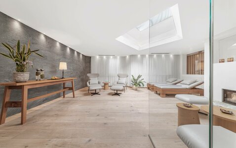 Ein heller Ruheraum mit Liegen, Sesseln und schlichten Holzmöbeln im Wellnessbereich des Hotel Hochschober.