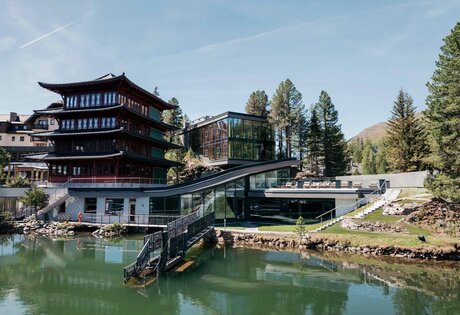 Das See-Bad mit Steg liegt vor dem Chinaturm und dem modernen Gebäudeteil des Hotel Hochschober am Seeufer.