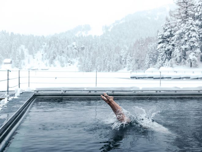 Der Mann badet im Winter in einem Seebad und macht einen Köpfler.