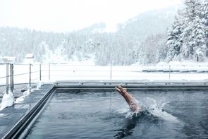 Der Mann badet im Winter in einem Seebad und macht einen Köpfler.